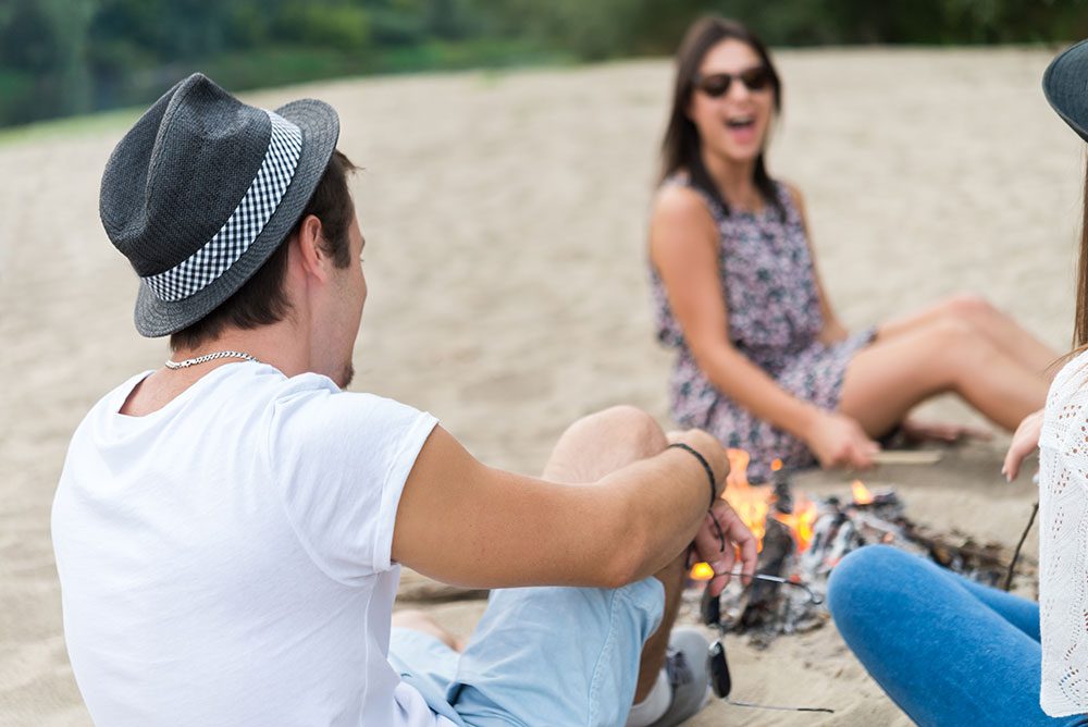 group of people having fun at a beach bonfire - fun in sobriety - summit bhc - addiction treatment centers nationwide 