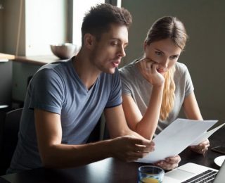 couple looking at forms and computer