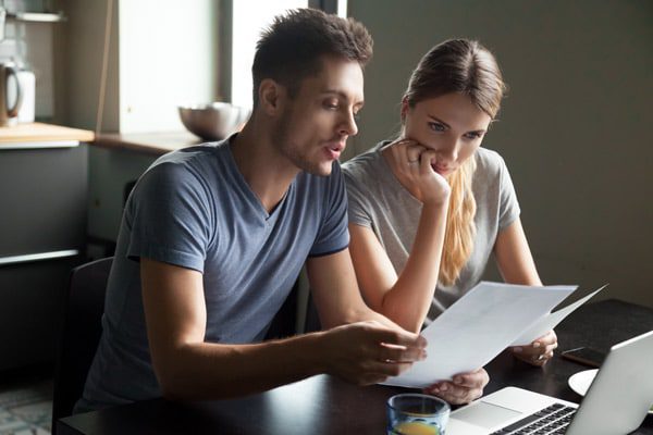 couple looking at forms and computer